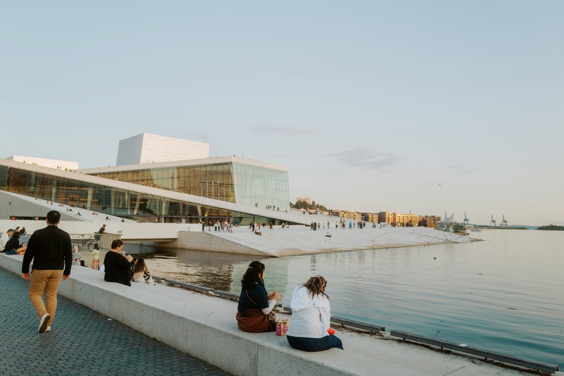 a group of people sitting next to a body of water
