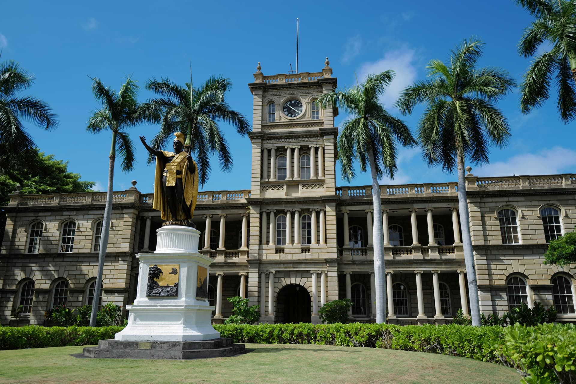 a statue in front of a large building with a clock tower